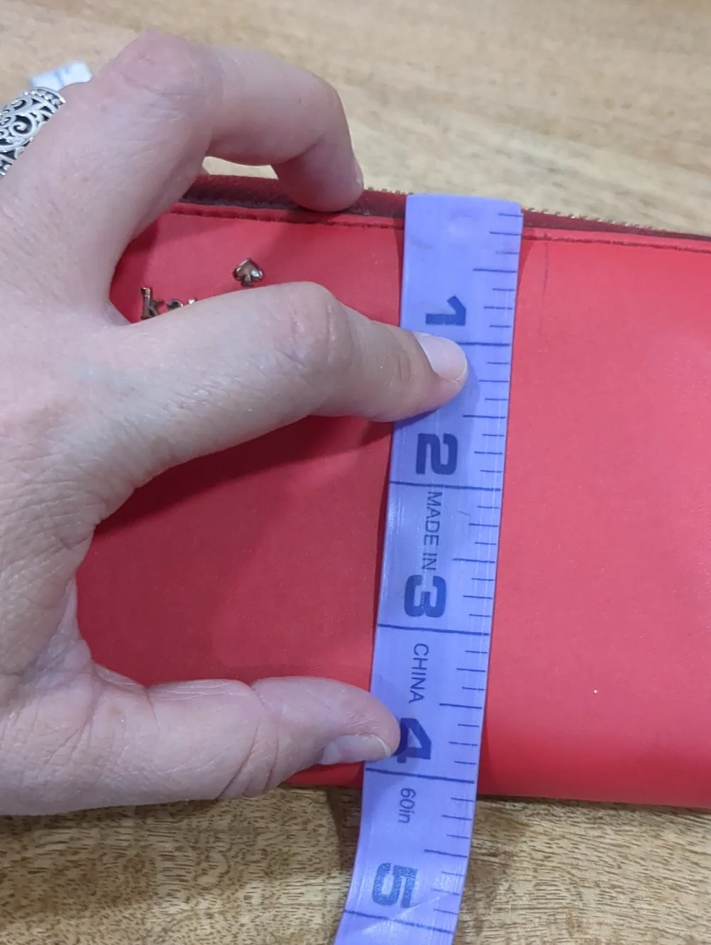 Kate Spade red zip-around wallet with Ace of Spades patch